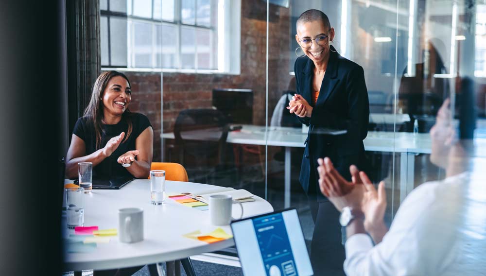 Happy,Young,Businesswoman,Being,Applauded,By,Her,Colleagues,During,A